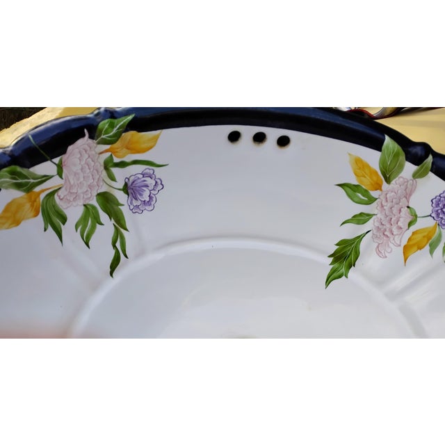 The botanical design is hand-painted on a Lotus oval drop in lavatory in white porcelain.