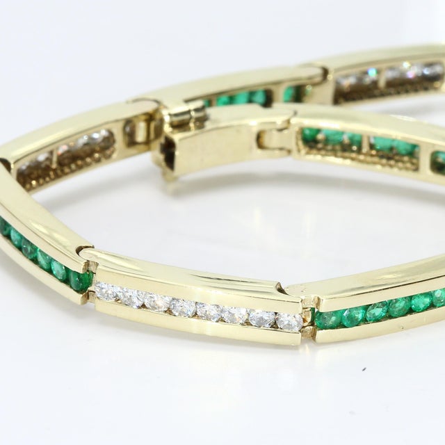 Here is a 14k Yellow Gold Tennis Bracelet featuring Brilliant White Diamonds and Emeralds, each weighing 0.04 carats. The...