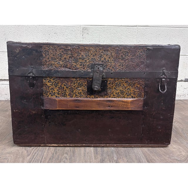 This is an authentic late 19th-century Victorian flat-top travel trunk featuring richly embossed floral tin panels, dark...
