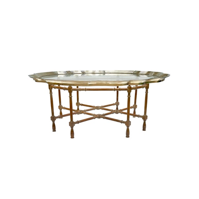 An elegant vintage Hollywood Regency tray table featuring a beautifully scalloped glass top framed in brass with faux...