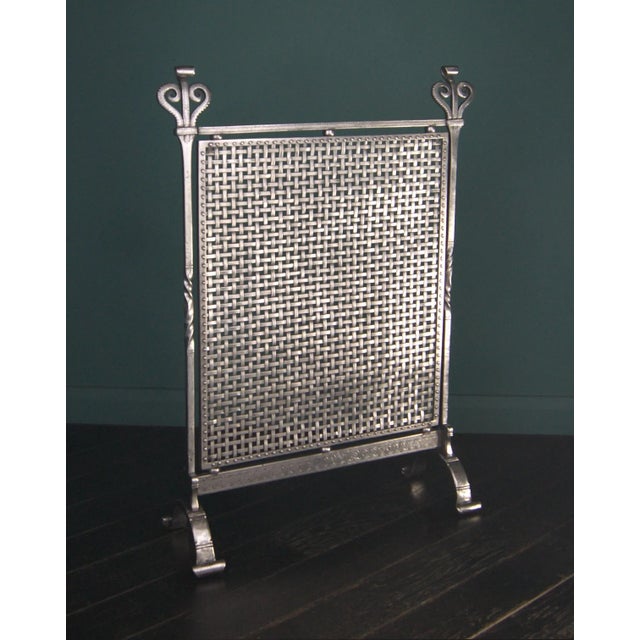 A finely engraved early 20th century polished wrought fire screen by c downer, campden, glos. The fire screen with densely...