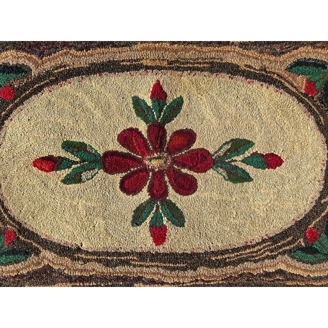 Vintage Hand-Hooked Floral Rug A charming vintage hand-hooked rug featuring a central floral medallion in deep red with...