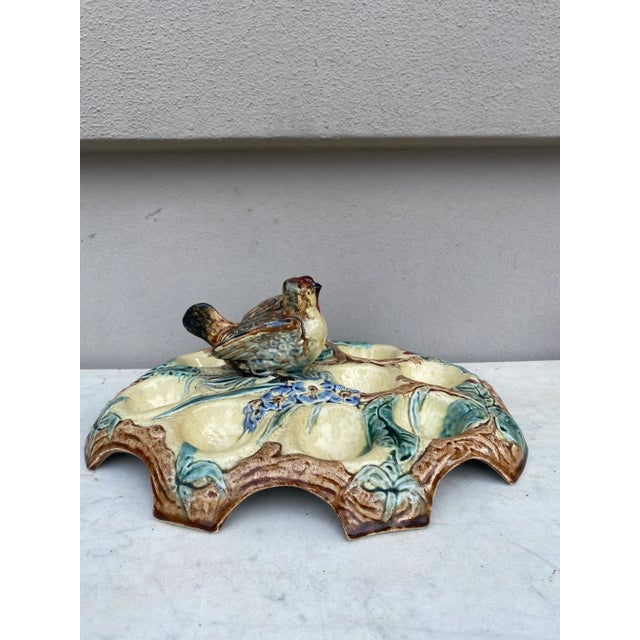 Belgium Majolica egg plate with bird handle for nine eggs decorated with flowers, butterfly and leaves, circa 1880.