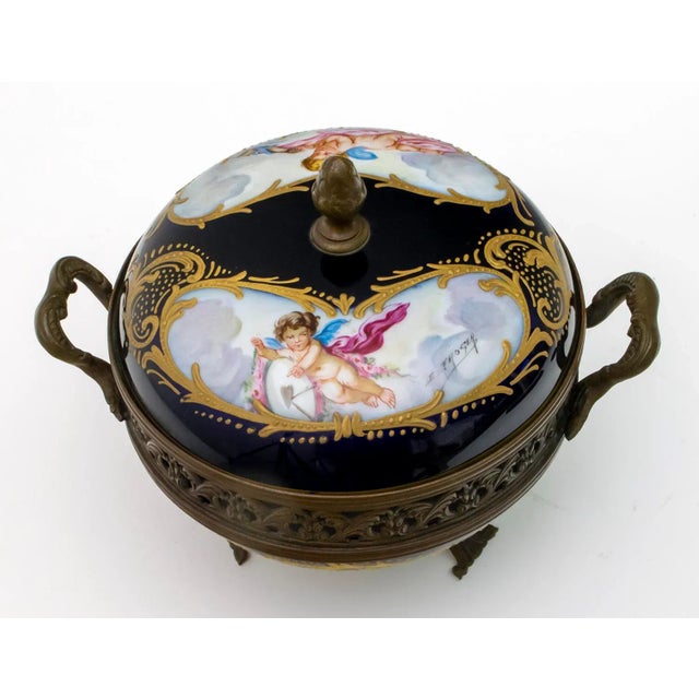 Cobalt blue and gold with two scrolls on the lid each with a winged cherub and a dove signed E. Froger. Perforated bronze...