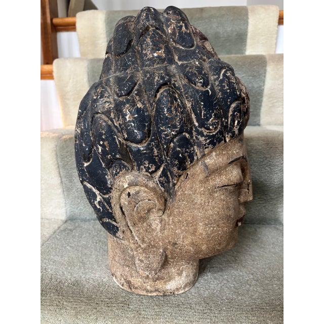 A carved and polychromed wooden Buddha head, probably late 19th/early 20th century, with beautiful features and a serene...