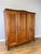 An elegant Vintage French Louis wardrobe in oak, featuring three beautifully shaped panelled doors, a sweeping curved top...
