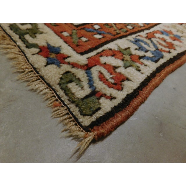 This antique Caucasian Genje Gallery rug features a striking geometric diagonal striped field patterned with stylized...