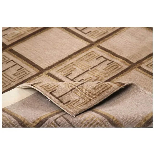 Handwoven rug featuring a Nepali design with a soft camel colored field accented in shades of brown and gold. Hand-woven...