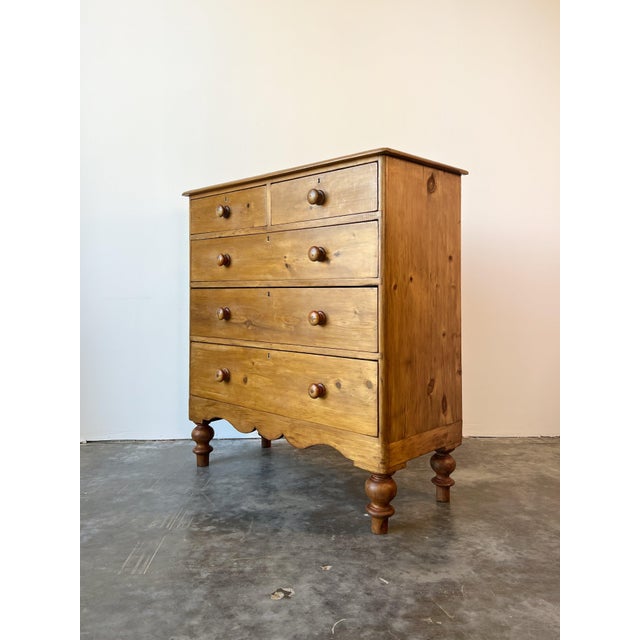 A charming scalloped front English antique chest of drawers with a useful configuration of two small drawers above three...