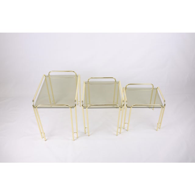 This elegant set of three vintage nesting tables from the 1970s perfectly embodies the Hollywood Regency aesthetic with a...