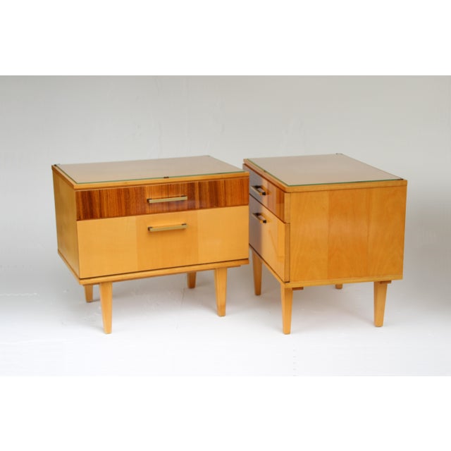 Set of two bedside tables, made in Germany in the 1960s. Light veneer (partly maple or birch) combined with brass handles...