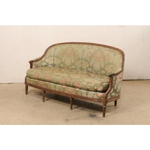 A Swedish period Gustavian upholstered and carved-wood sofa from the early 19th century. This antique tub style sofa from...