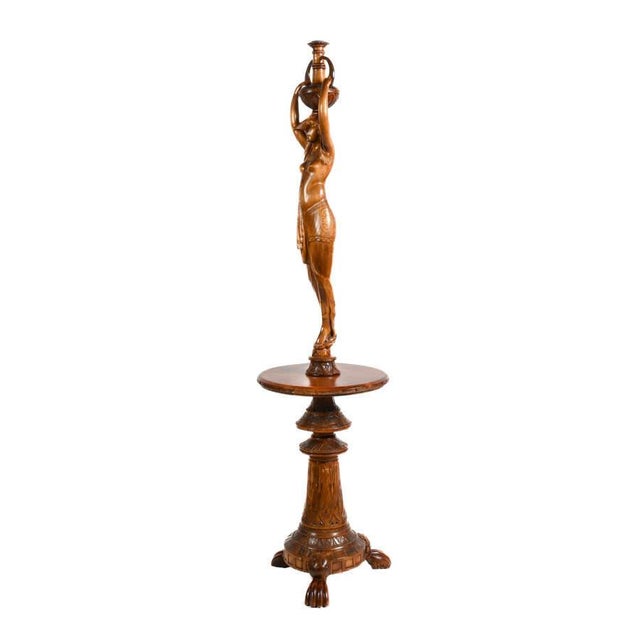 Dramatic and sculptural, this carved wood pedestal table draws inspiration from the enduring allure of Egyptian Revival...