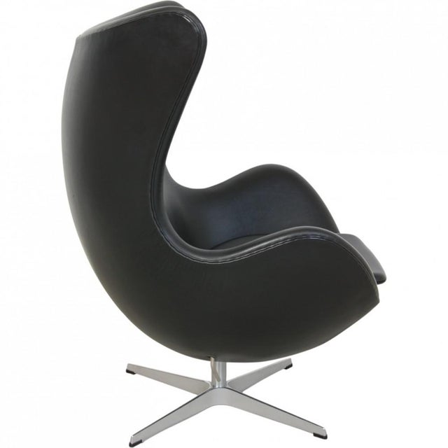 Arne Jacobsen Egg chair upholstered in original black Aura leather, and with a base of brushed aluminium. The chair is...