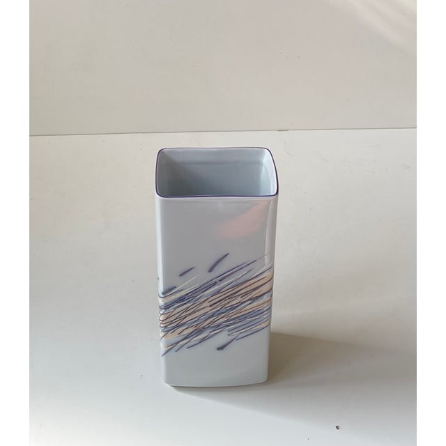 Modernist rectangular porcelain vase decorated with stylized rush grass in shades of purple and blue over a white...