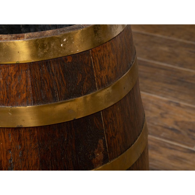 An English Victorian period wooden oval shaped barrel from the 19th century with painted coat of arms and brass braces....