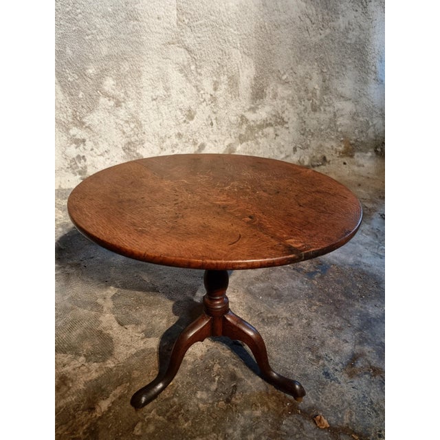 This Georgian oak tilt-top table was made in England around 1800 and represents the refined craftsmanship of the late...