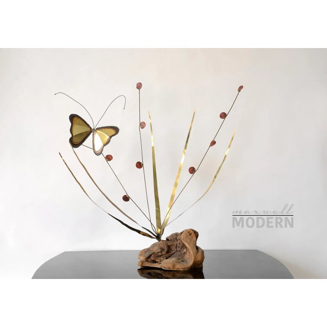 A very pretty vintage brass sculpture of a butterfly on a wild plant with a driftwood base. The circular leaves on three...