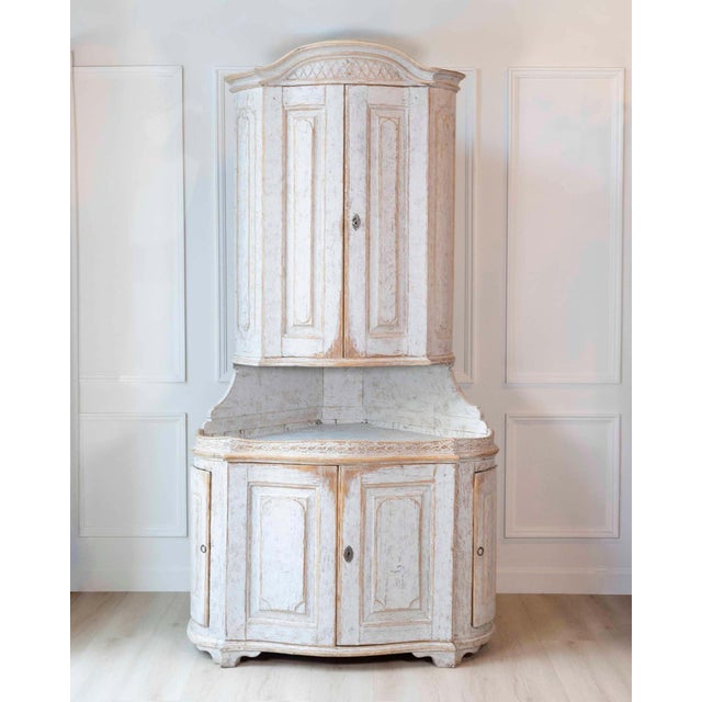 A Swedish Gustavian period two-part corner cabinet from the late 18th century, designed to maximize space while...