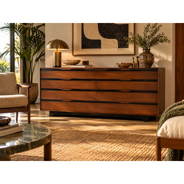 A John Stuart low dresser featuring warm wood and contrasting dark details. Its long, clean-lined design offers eight...