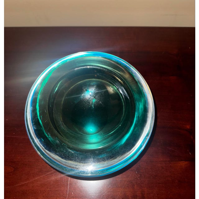 Substantial emerald green cased art glass bowl attributed to Murano, Italy. This striking decorative piece features deep...