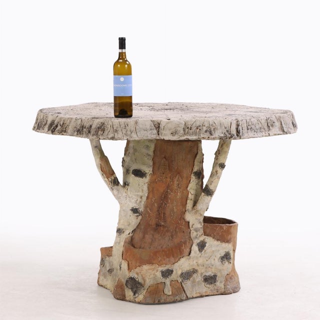 Constructed of two pieces, this whimsical table has a top which imitates a wood slice with the growth rings resting on a...