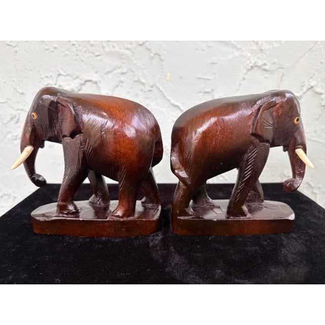 Charming pair of vintage hand-carved wooden elephant figurines, crafted from solid hardwood and finished in a warm...