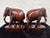 Charming pair of vintage hand-carved wooden elephant figurines, crafted from solid hardwood and finished in a warm...