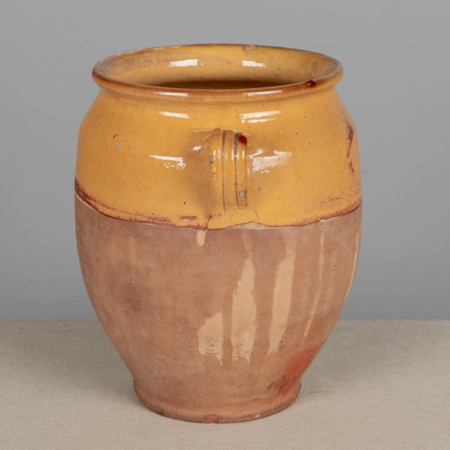 An earthenware confit pot from the Southwest of France with traditional yellow glaze. Minor losses to glaze. These...