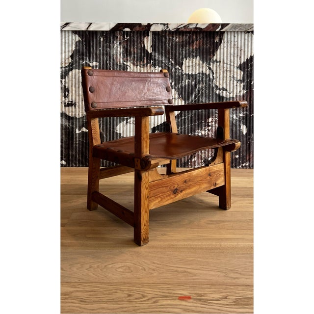 1970s Spanish lounge chairs with sculptural solid- pine wood frames and rich leather sling seats.