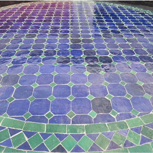 Beautiful handcrafted Moroccan mosaic table featuring an elegant blue and teal color palette. Measuring 52 inches in...