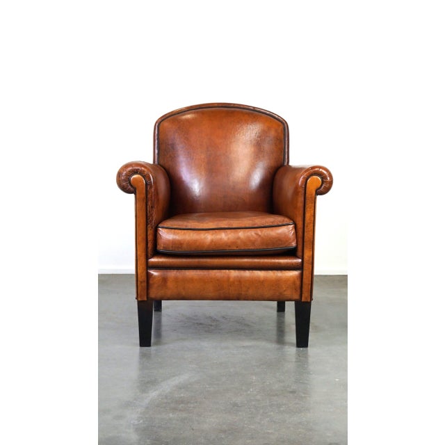 This charming vintage armchair has a warm color and is made of sheepskin. It fits easily into almost any interior and...