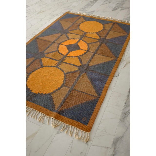 Beautiful Vintage Swedish rug by Brita Swefors. Geometric shapes in burnt orange, blue and brown shades creates a stunning...