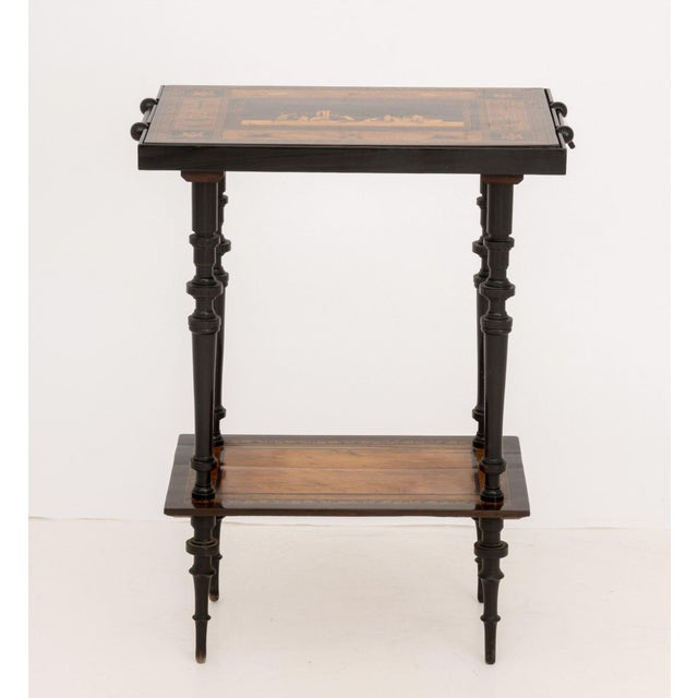 Italian Two-Tier Marquetry Ebonized Games Table, 19th century, the Sorrento wood inlay reversible top with central figural...