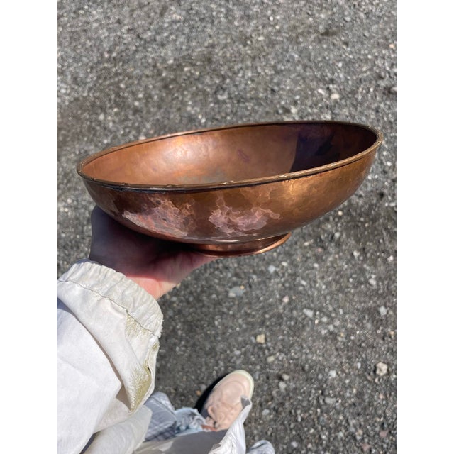 An Arts & Crafts hand-hammered copper bowl on a pedestal with a handsomely executed lip. Appears to have been used as a...
