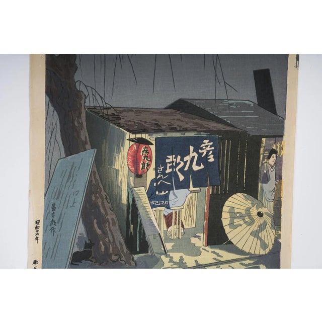 Vintage mid 20th century woodblock print on paper by Tokuriki Tomikichiro (1902-2002) Japan. Noodle Shop at Night, circa...