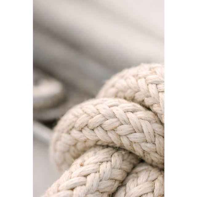 Minimalist coastal artwork featuring a detailed rope knot with soft neutral tones and textured weave. The composition...