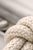 Minimalist coastal artwork featuring a detailed rope knot with soft neutral tones and textured weave. The composition...