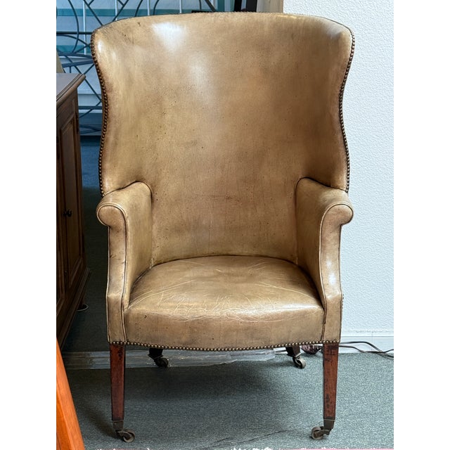 Design Plus Gallery presents a Studded Leather Wingback Chair in the George II Style. The chair has enclosed sides that...
