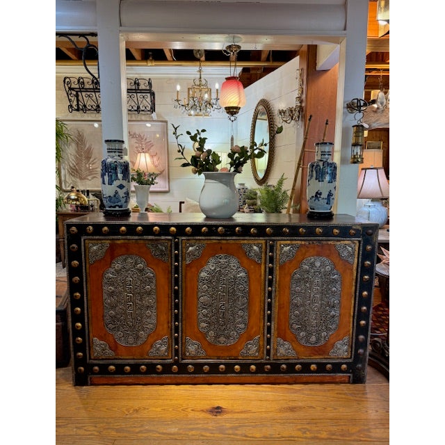 Large Asian credenza, storage cabinet with 3 doors. Lots of storage. Cabinet has a distressed wood finish with ornate...