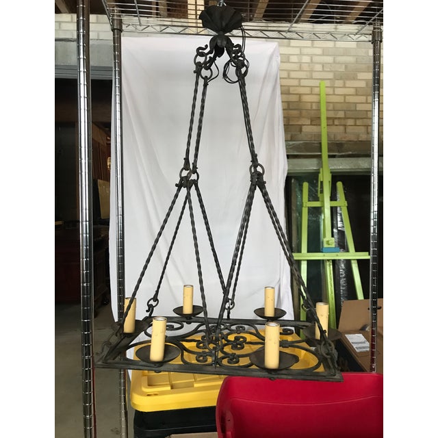 This impressive French iron rustic chandelier is made of heavy wrought iron. It features 6 arms attached to an open scroll...