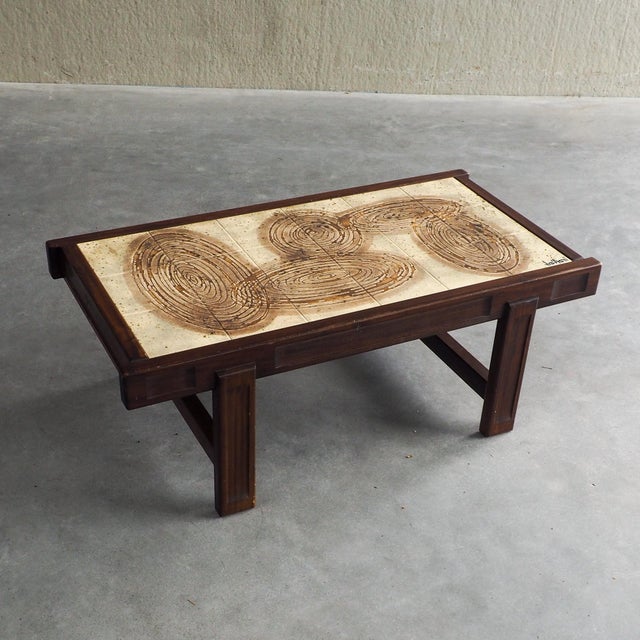 Striking mid-century modern coffee table featuring hand-painted ceramic tiles signed by artist Jean D'Asti a French...