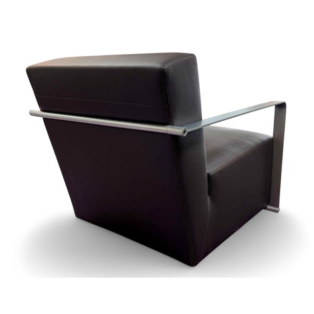 A pair of high-end Brando Armchairs by CasaDesús. Features dark brown leather upholstery with brushed stainless steel arms...