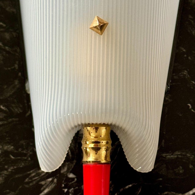 Striking pair of wall sconces composed of molded ribbed plastic diffusers with brass accents and vivid red tapered...
