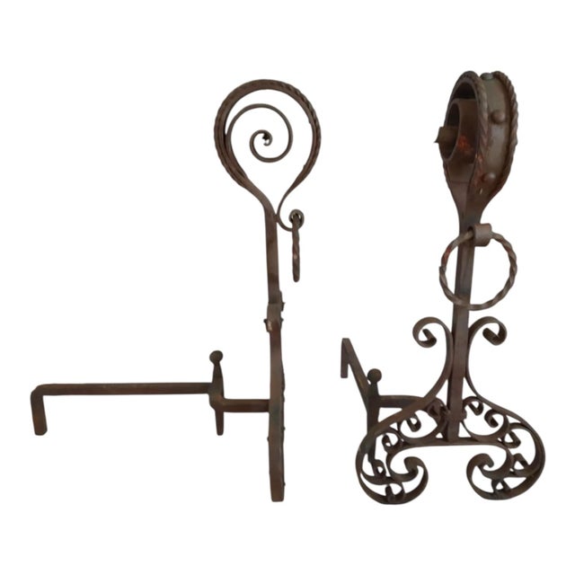 This is a pair of 19th century French gothic revival hand forged wrought iron fireplace andirons with scrollwork. They are...