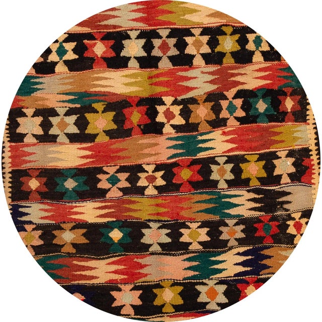 A beautiful hand-woven vintage kilim runner with a tan field, and multi-color accents in an all-over geometric design....