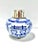 A petite vintage blue-and-white porcelain tea jar decorated with bold floral motifs and topped by a polished metal lid....