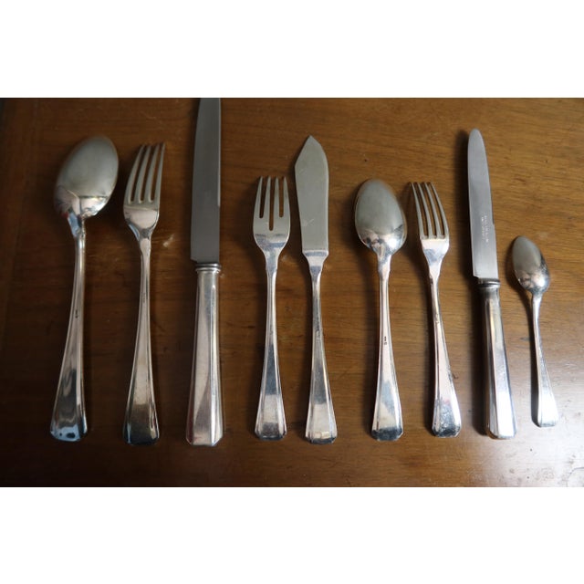 A silver-plated flatware set comprising 116 pieces, housed in a wooden case with drawers. The set includes: 12 dinner...