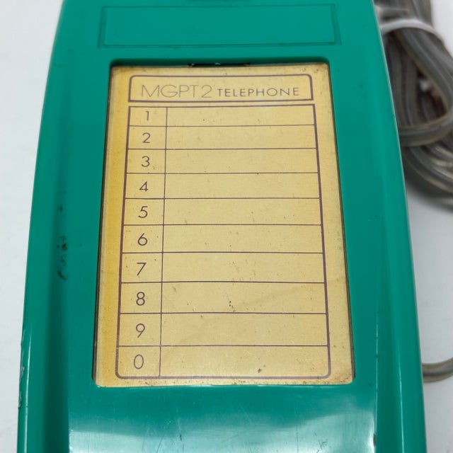 A vintage 1980s or 1990s trimline telephone, in a striking bright teal color. Good vintage condition.