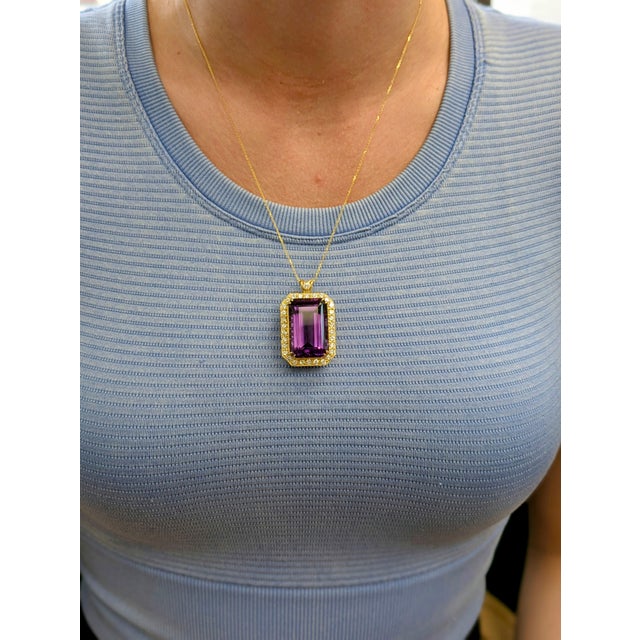 This dramatic statement pendant showcases a vivid 22-carat emerald-cut Zambian amethyst (27.5x18.5mm), wrapped in a...